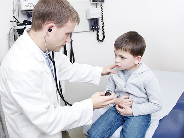 Arzt der Notaufnahme hört Jungen mit Stethoskop ab